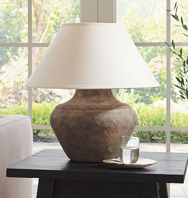 Earthy, aged textures and finishes give this shapely table lamp an extra allure